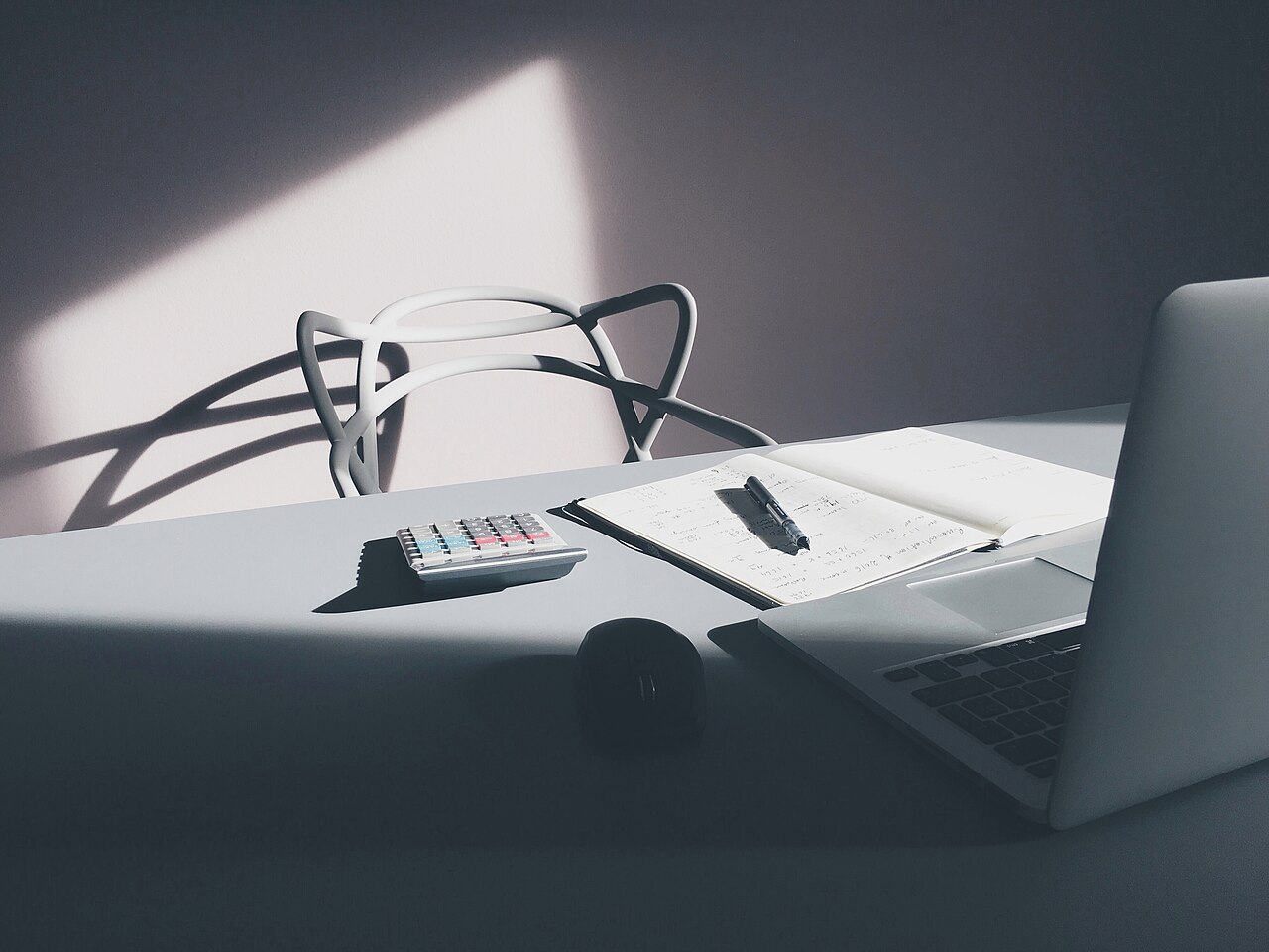 Desktop computer with a laptop and calculator on a work desk